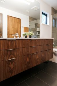 Frameless vertical grain walnut vanity with undermount sink and quartz top