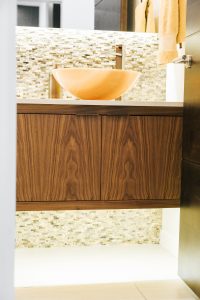 inset floating walnut vanity with quartz counter and vessel sink.