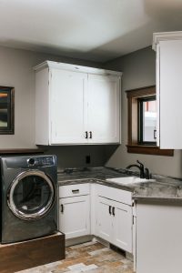 Laundry room with Rustic Alder painted white cabinets with rub thru
