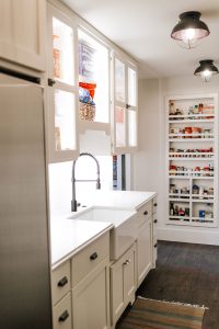 Navajo White Pantry with cloverleaf wire panel inserts, farm sink and panel ready dishwasher