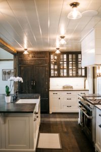 Rustic Oak Skip Sawn paneled refrigerator and 6 lite glass doors with Navajo White bases