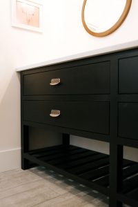 Inset vanity cabinet painted Tricorn Black with slatted wood shelf