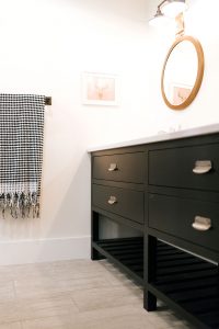 Inset vanity cabinet painted Tricorn Black with slatted wood shelf