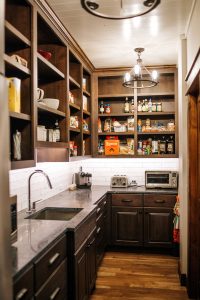 Rustic Alder pantry with open finished cabinet uppers, extra refrigerator and sink