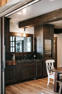 Rustic Alder with white and black glaze bar cabinets with built-in wine cooler, butcher block and soapstone countertop