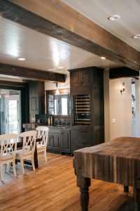 Rustic Alder with white and black glaze bar cabinets with built-in wine cooler, butcher block and soapstone countertop