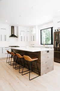 Two toned Kitchen with white perimeter cabinets, rustic soft maple book matched horizontal grain island