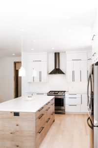 Two toned Kitchen with white perimeter cabinets, rustic soft maple book matched horizontal grain island